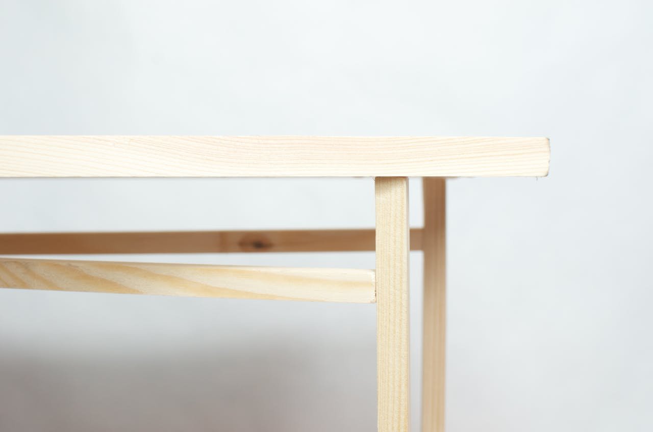 Wooden piece of furniture with flat top placed in minimal studio against white background